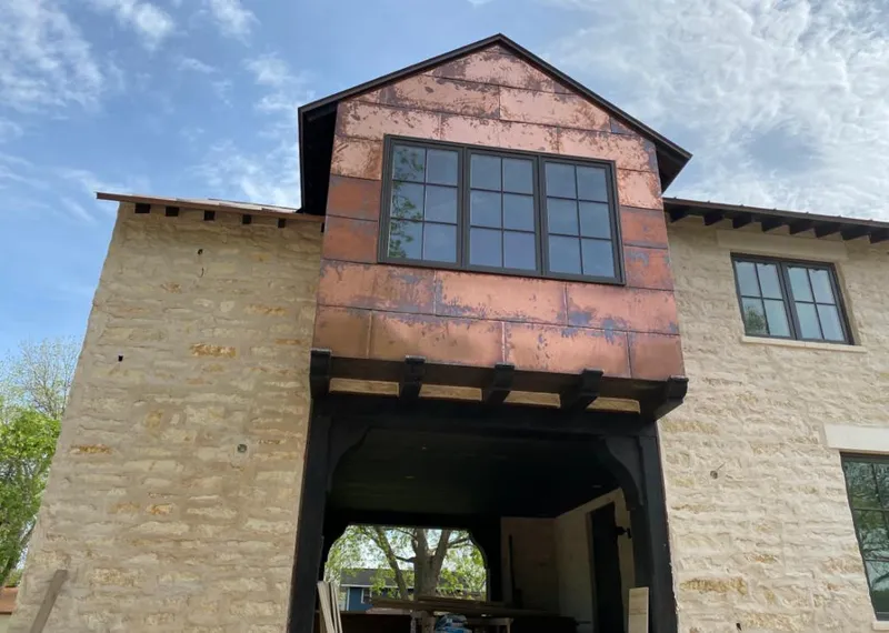 Copper metal panel facade on a stone building for Skylight Installation in Niles
